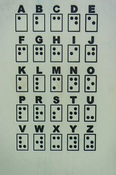 白い面に縦に並んだ点字のアルファベット — ストック写真