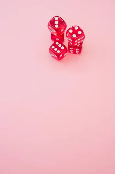 骰子在孤立的粉色背景上打骰子的一个垂直的高角度的镜头 — 图库照片