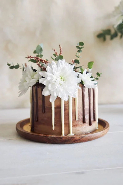 白と黒のチョコレートと花が渦巻くおいしいケーキ — ストック写真