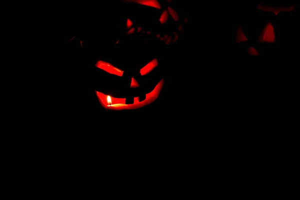 ハロウィンのお祝いのための工芸品として作られた手彫りの邪悪なカボチャとキャンドルでライトアップ 神秘的な雰囲気と赤の光を作成します — ストック写真