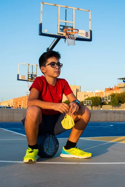 Vertical Shot Boy Sitting Ball Court Holding Sanitary Mask — ストック写真