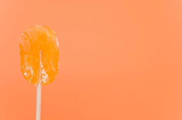 孤立したオレンジの背景にロリポップのクローズアップショット — ストック写真