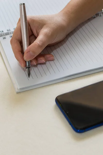 Una Toma Vertical Manos Femeninas Escribiendo Cuaderno Espiral Colocado Escritorio — Foto de Stock