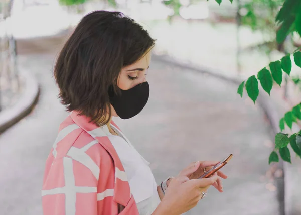 Una Mujer Mirando Teléfono Usando Una Máscara Protectora — Foto de Stock