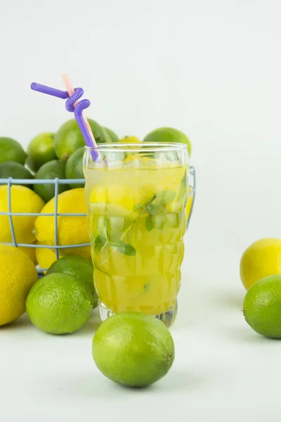 Glass Fresh Lemonade Citruses Heap Lemons Limes Background — Stock Photo, Image