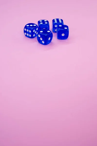 蓝色骰子的垂直镜头 在浅粉色背景上隔离 — 图库照片