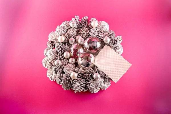 Una Corona Navidad Con Conos Blancos Sobre Fondo Rosa —  Fotos de Stock