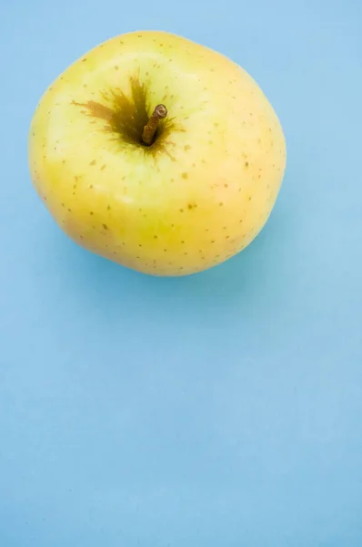 Eine Vertikale Aufnahme Des Gelben Apfels Isoliert Auf Blauem Hintergrund — Stockfoto