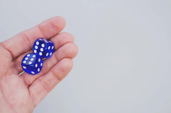 一只手拿着蓝色骰子在白色背景上隔离的特写镜头 — 图库照片