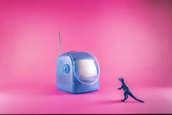 Ein Spielzeugfernseher Mit Einem Drachen Auf Rosa Hintergrund — Stockfoto