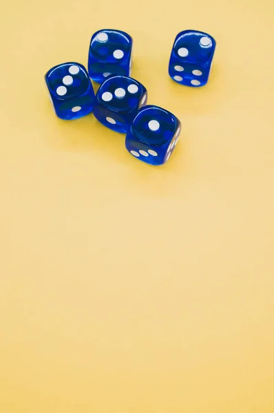 黄色底色上的蓝色骰子的垂直射击 — 图库照片