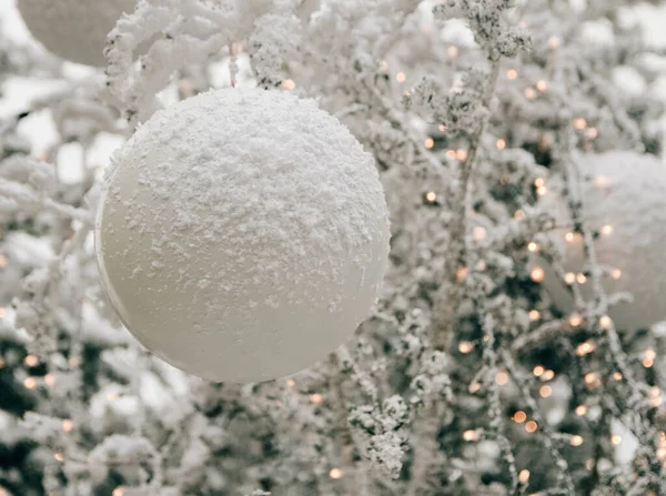 Een Closeup Van Witte Ornamenten Een Kerstboom Bedekt Met Sneeuw — Stockfoto