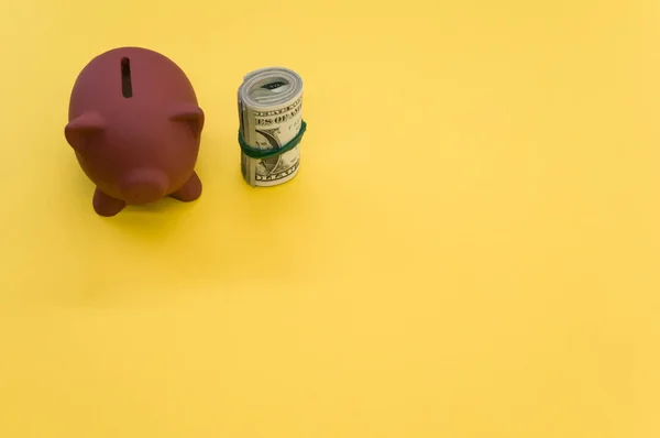 一张高角度的美元钞票和一个黄色表面上的储蓄罐 — 图库照片
