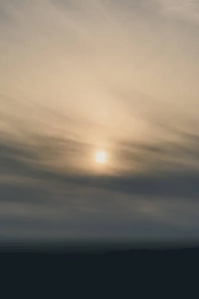 Удивительный Вертикальный Снимок Едва Заметного Заходящего Солнца Красивым Облачным Пейзажем — стоковое фото