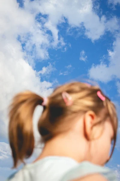 青い空の美しい少女の垂直低角度のショットのフレーム — ストック写真
