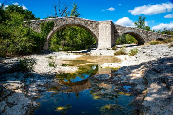 在清澈的天空背景下 一座横跨干涸河流的古老石拱桥的景观 — 图库照片
