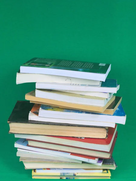 Вертикальний Знімок Книг Складених Один Одного Зеленому Тлі — стокове фото