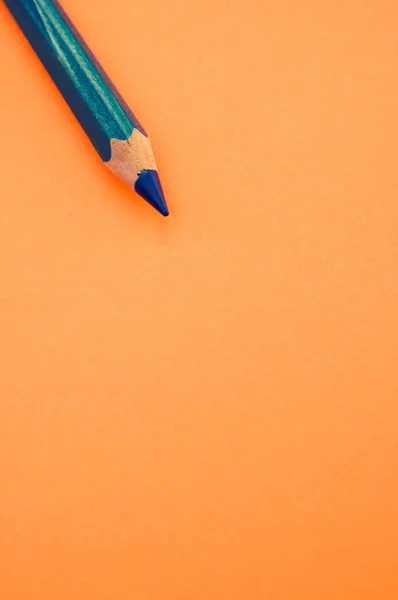 주황색 배경에 분리날카로운 파란색 연필의 — 스톡 사진