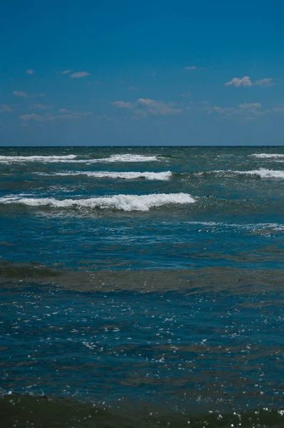 Pionowe Ujęcie Błękitnego Falistego Morza Pod Czystym Niebem — Zdjęcie stockowe
