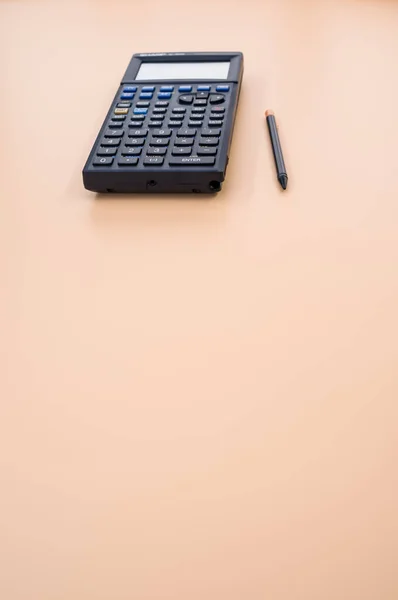 Una Toma Vertical Una Calculadora Bolígrafo Sobre Fondo Melocotón — Foto de Stock