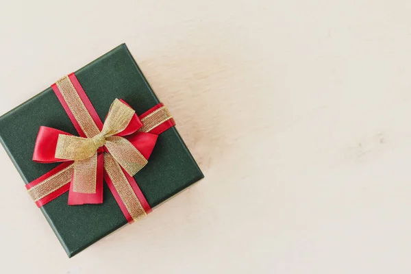 一个圣诞礼品盒 白色背景上有红色和金色的蝴蝶结 — 图库照片