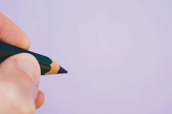 灰色の背景に青い鉛筆を持っている者の閉鎖 — ストック写真