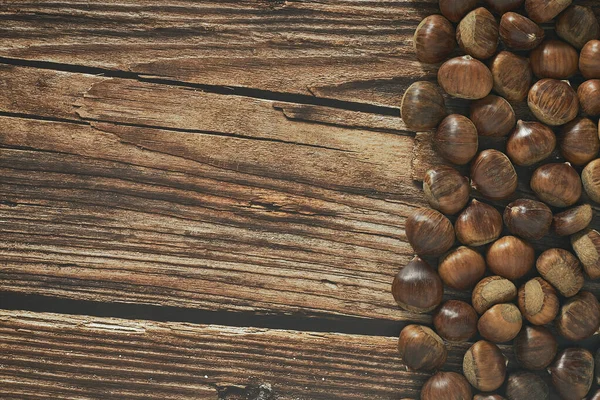 テキストのためのコピースペースと茶色の木製の背景に栗のトップビュー — ストック写真