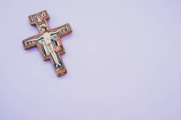 薄い紫色の背景に孤立した装飾された木製の十字の高角度ショット — ストック写真