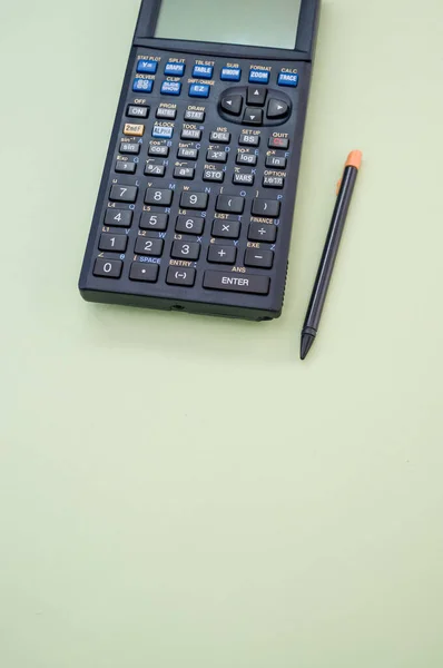 Вертикальный Снимок Калькулятора Ручки Зеленом Фоне — стоковое фото
