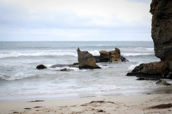 岩の多い海岸近くで砕ける泡の波の接近ショット — ストック写真