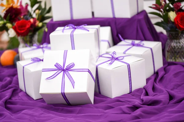 一张桌子上有紫色带子的白色盒子的照片 — 图库照片