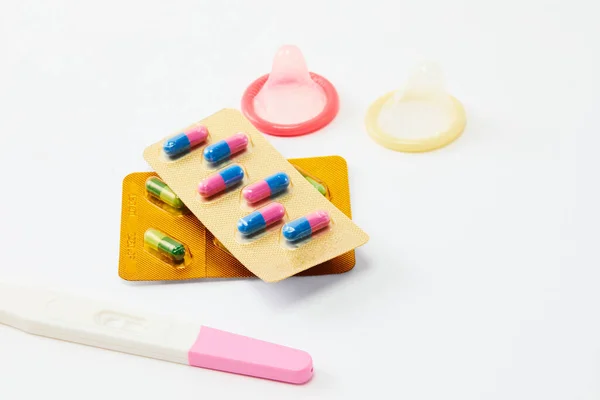 A top view of birth control pills, condoms and pregnancy test isolated on a white background