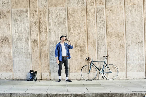 Profesyonel Serbest Çalışan Bisikletli Dışarıda Bir Duvarın Önünde Kahve Içen — Stok fotoğraf