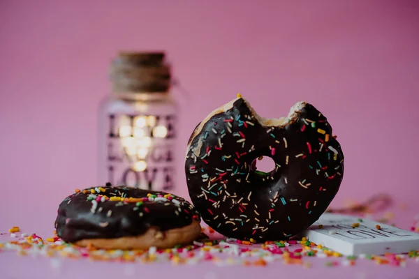 Närbild Bild Läckra Chokladmunkar Med Strössel Och Kärleksnoter Rosa Bakgrund — Stockfoto