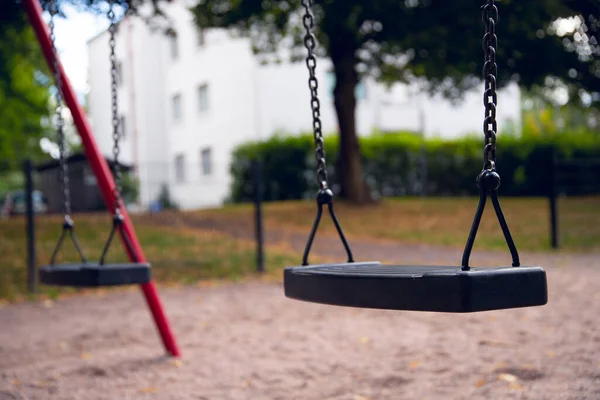 Eine Schwarze Schaukel Mit Roten Pfählen Auf Einem Spielplatz — Stockfoto