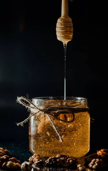 Ein Vertikaler Schuss Honig Glas Mit Walnüssen Und Holzdipper — Stockfoto