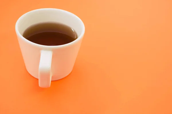 テキストのためのスペースとオレンジの背景にお茶のカップの閉鎖 — ストック写真
