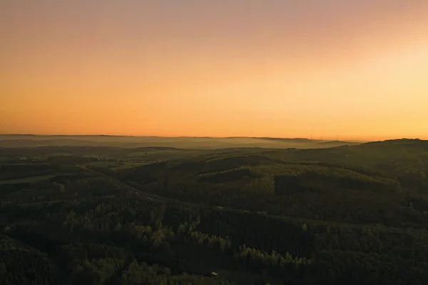 Eine Luftaufnahme Einer Bergigen Gegend Die Bei Sonnenuntergang Von Bäumen — Stockfoto