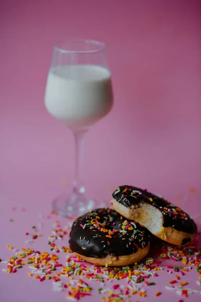 Colpo Verticale Ciambelle Cioccolato Con Spruzzi Bicchiere Latte Isolato Fondo — Foto Stock