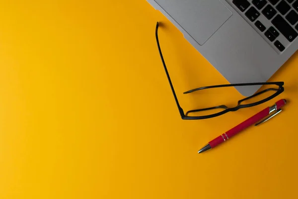 黄色のテーブルにノートパソコンのトップビュー — ストック写真