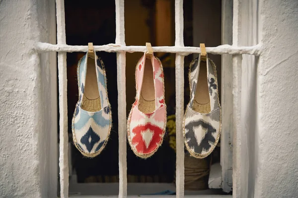 A closeup shot of shoes hanging on a window grate