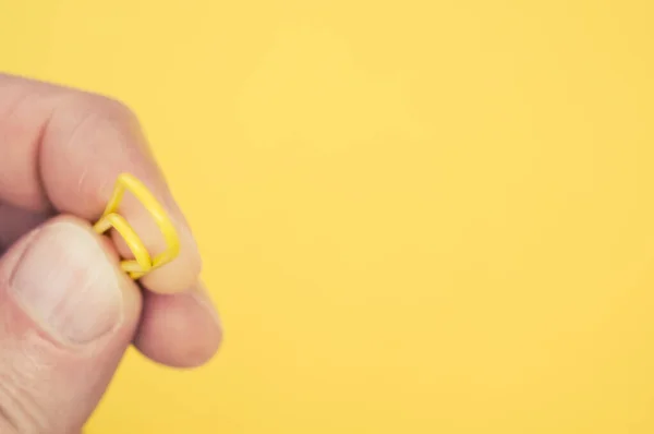 Een Close Shot Van Een Gele Paperclip Een Hand — Stockfoto