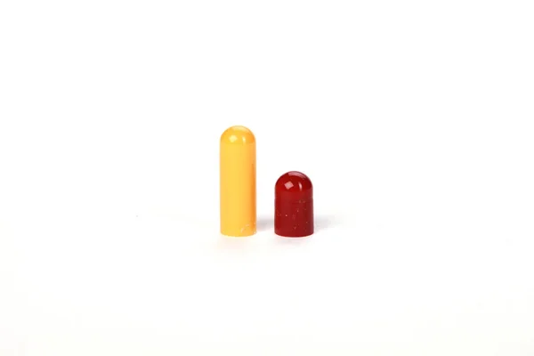 一种开了的红色和黄色胶囊 在白色的背景上隔离 — 图库照片