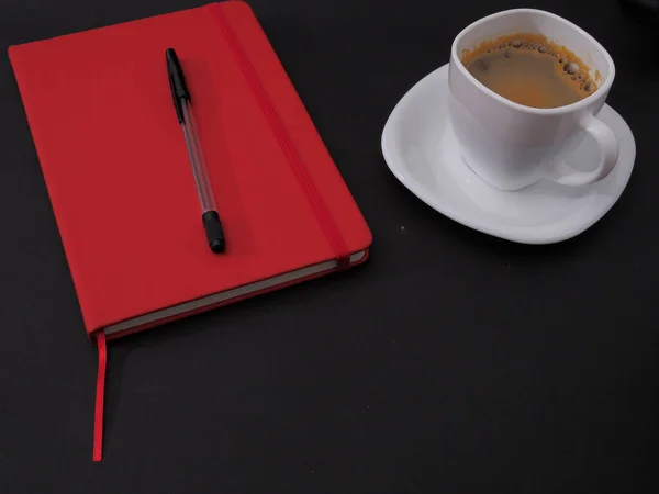 一张用钢笔和一杯咖啡的红色笔记本的特写照片 — 图库照片