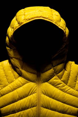 A vertical shot of a yellow down jacket on black background clipart