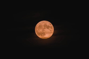 A bright full moon captured in the dark sky at night clipart