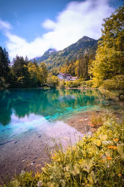 Plano Vertical Lago Cristalino Rodeado Montañas Cubiertas Vegetación Bajo Luz — Foto de Stock