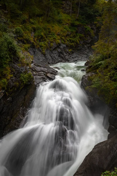 Vertikální Záběr Krásného Vodopádu Obklopeného Skálami Pokrytými Zelení Ponurého Dne — Stock fotografie