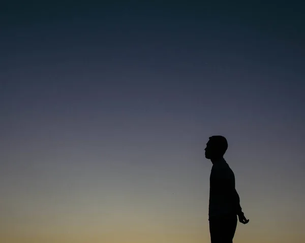 Die Silhouette Eines Nachdenklichen Jungen Mannes Mit Klarem Nachthimmel Dahinter — Stockfoto