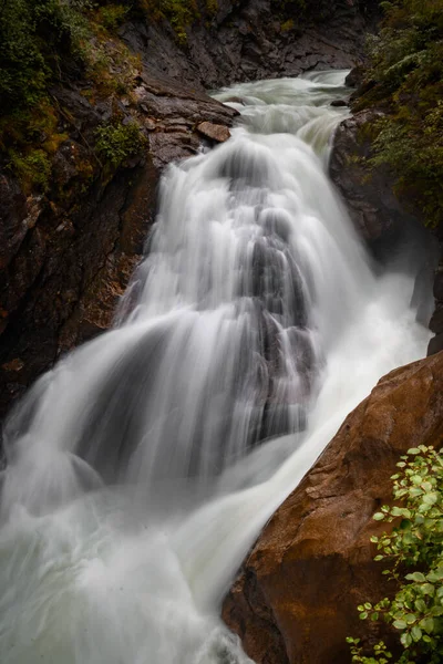 Вертикальний Знімок Красивого Водоспаду Оточенні Скель Вкритих Зеленню Похмурий День — стокове фото
